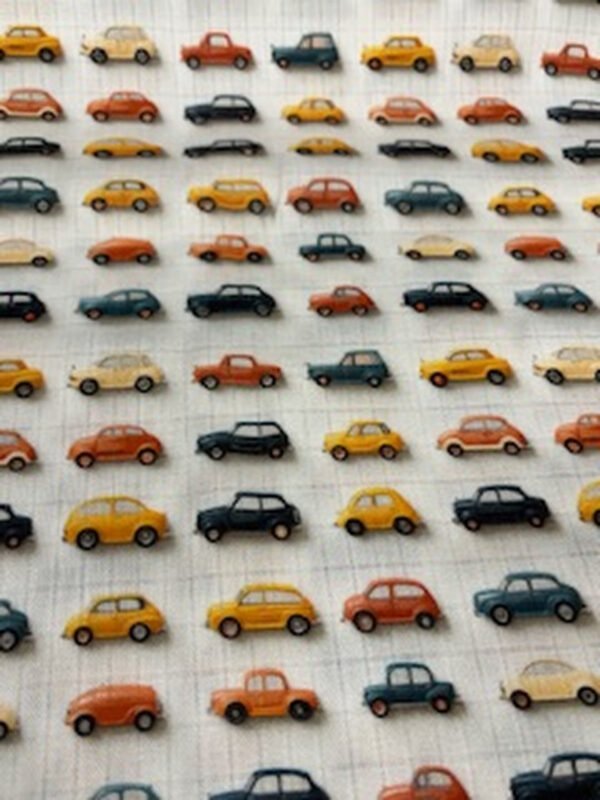 Barevné hračky autíčka uspořádané v řadách.