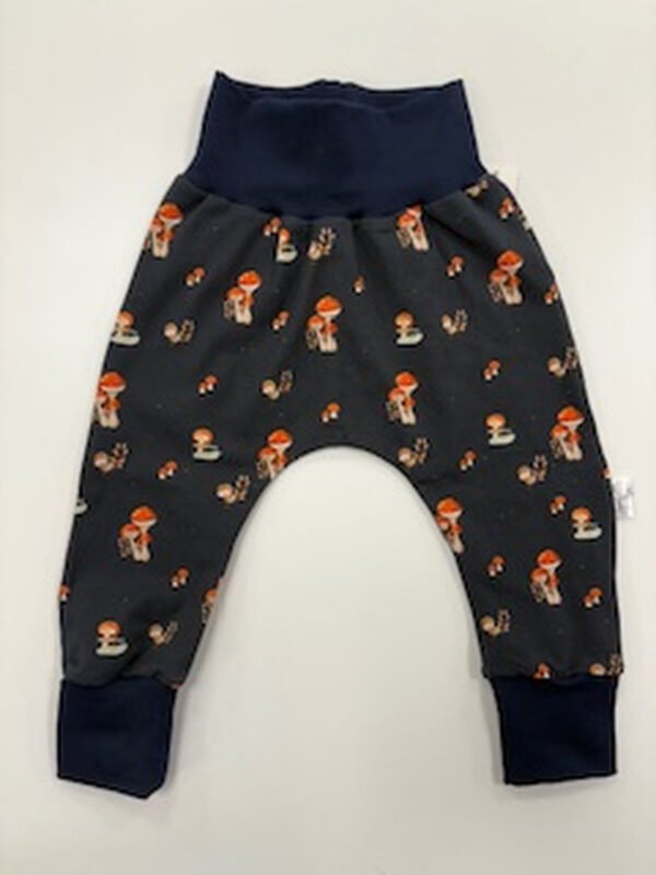 Dětské kalhoty s motivem hub na tmavém podkladě.