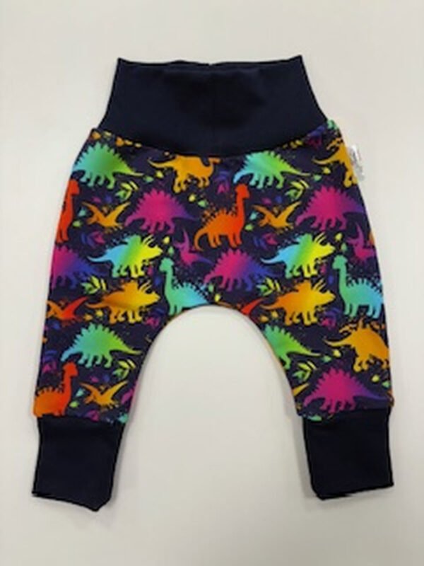 Dětské kalhoty s barevnými dinosaury na tmavém podkladu.