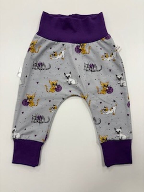 Dětské kalhoty se vzorem koček a fialovým lemem.