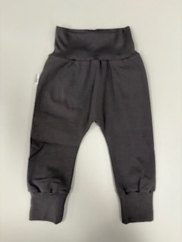 Dětské tmavě šedé kalhoty na stole.