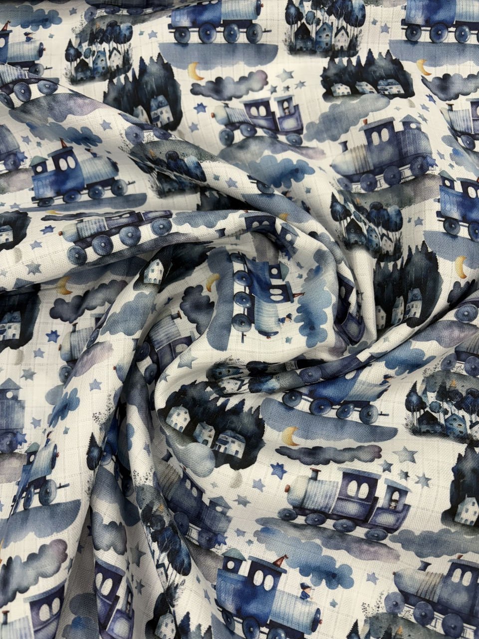 Látka s modrými vlaky a hvězdami, dětský motiv.