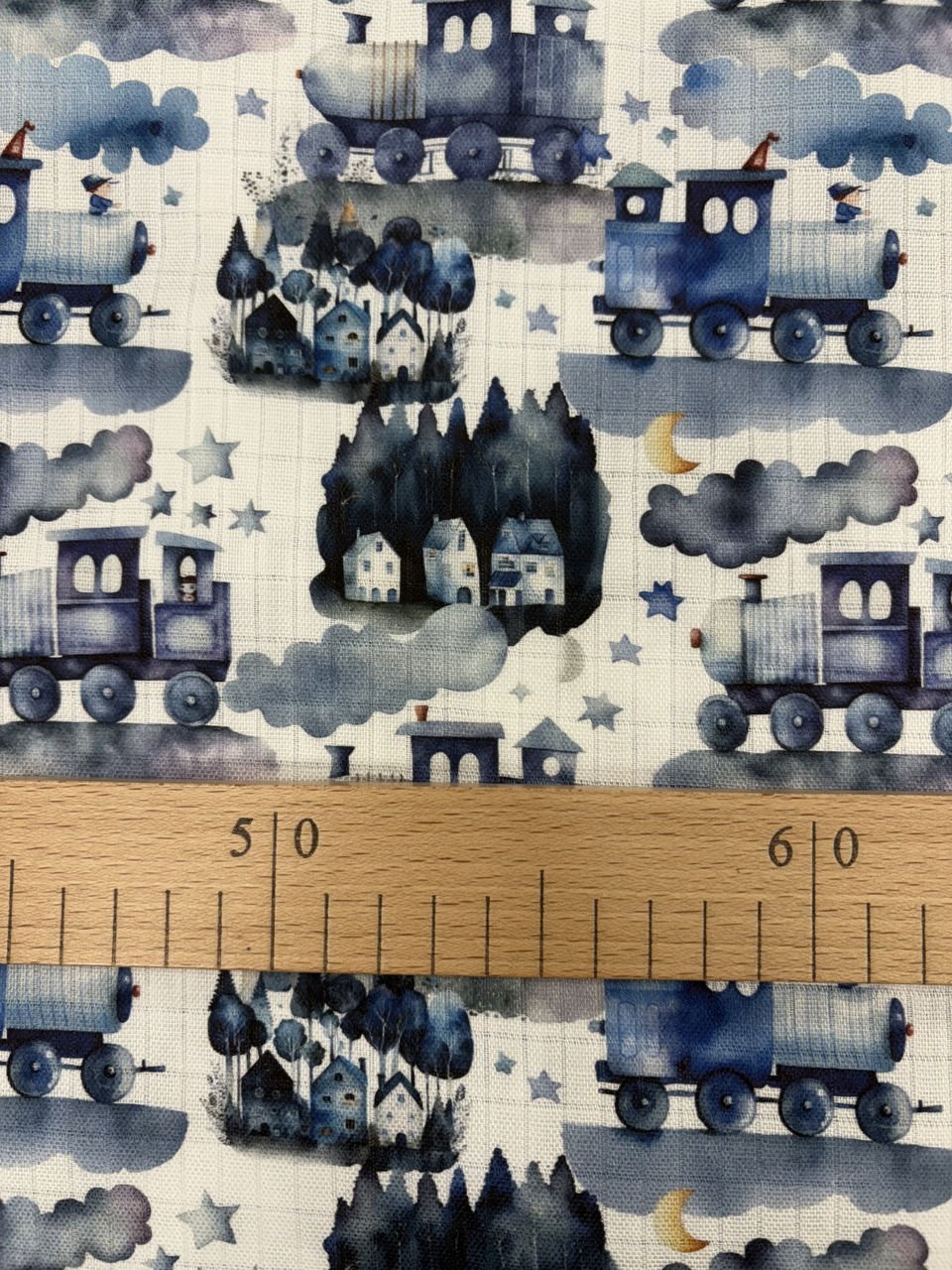 Modré vlaky a domečky na textilním potisku.
