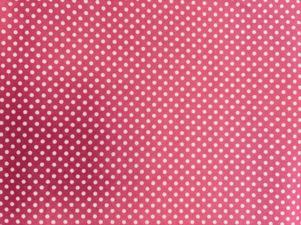 Růžová látka s bílými puntíky na povrchu.