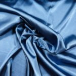 Záhyby modré saténové látky