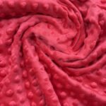 Červená látka s puntíkovanou texturou