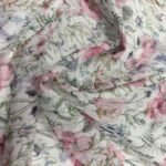 Bílé květinové plátno s růžovými a zelenými vzory.