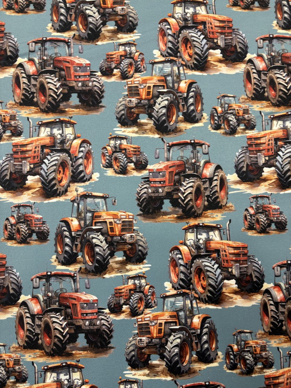 Opakující se vzor červených traktorů na modrém pozadí.