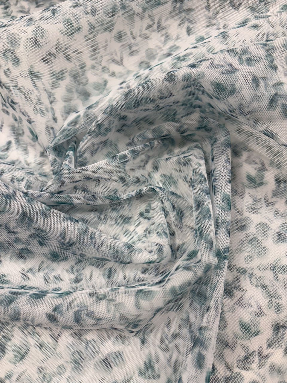 Bílá látka se zeleným květinovým vzorem