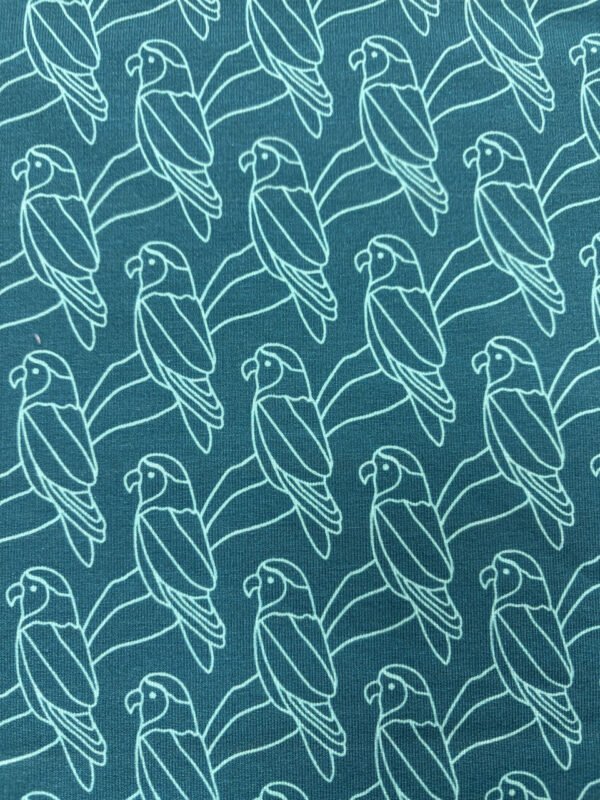 Vzor papouška na modrém pozadí látky.