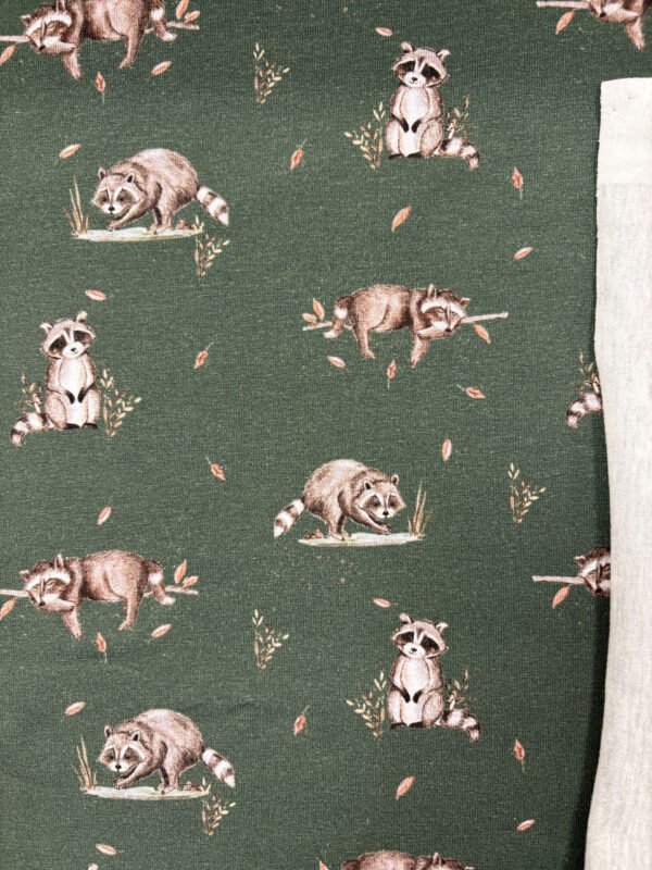 Látka se vzorem malovaných mývalů a listů.