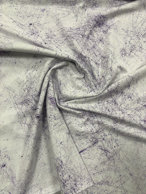 Bílá látka s fialovým abstraktním vzorem