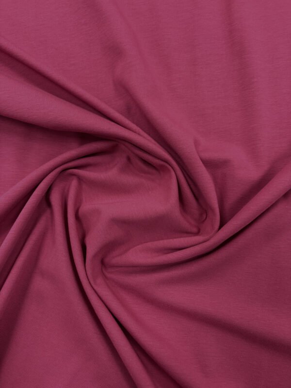 Detail růžové látky, textilní textura.