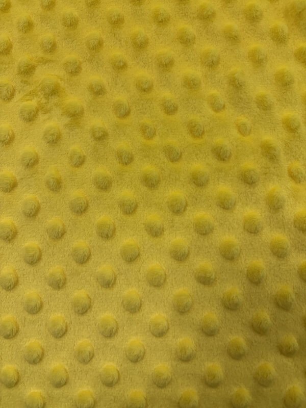Žlutá látka s vyčnívajícími kulatými vzory