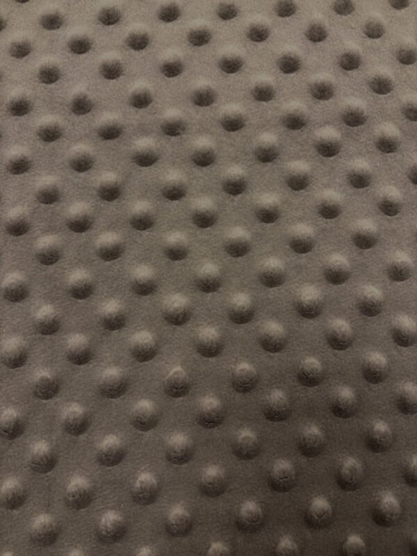 Textura šedé látky s výstupky.