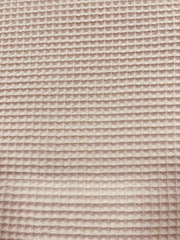 Detail textily s vaflovým vzorem v béžové barvě.