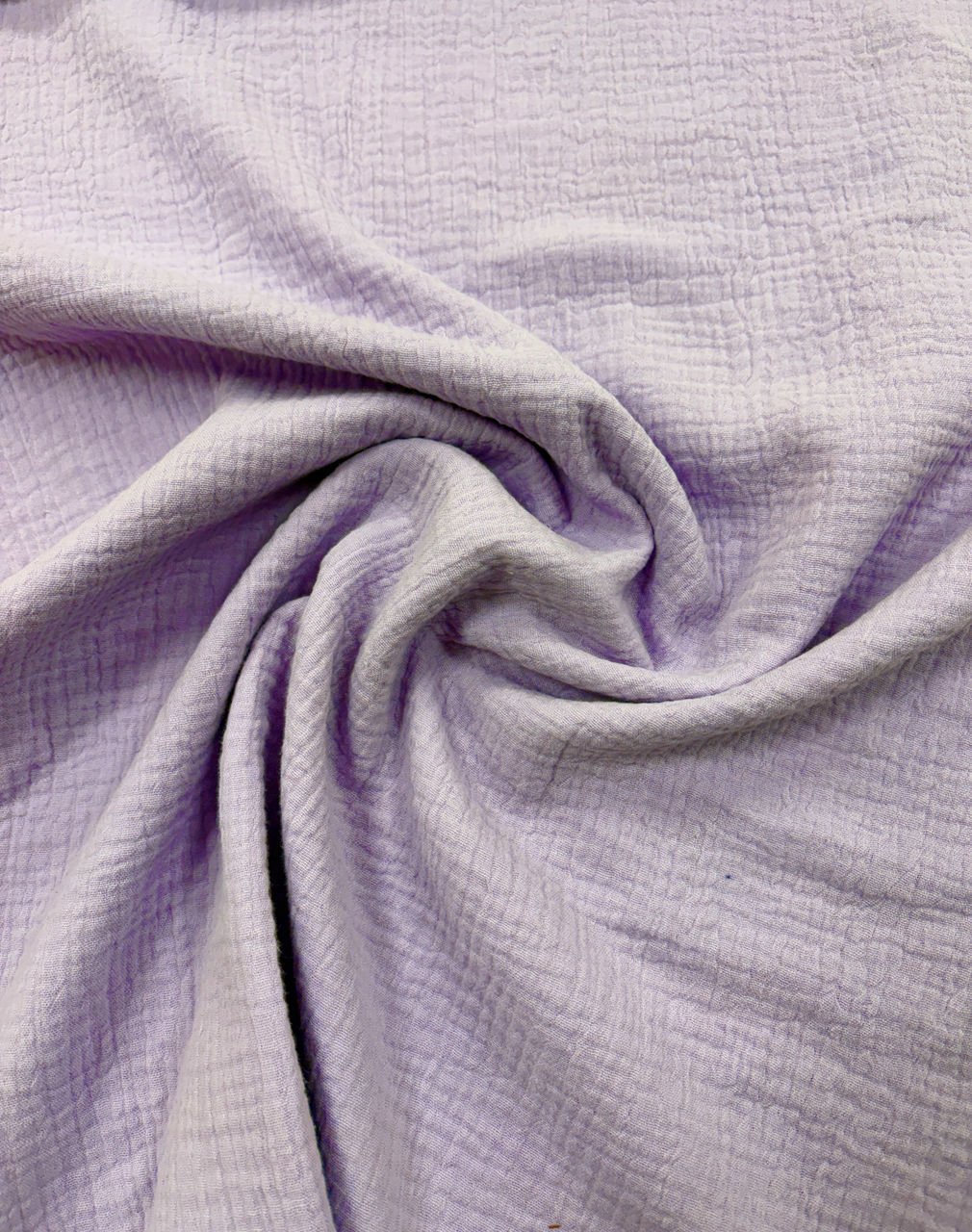 Lehká fialová látka s jemným vzorem.