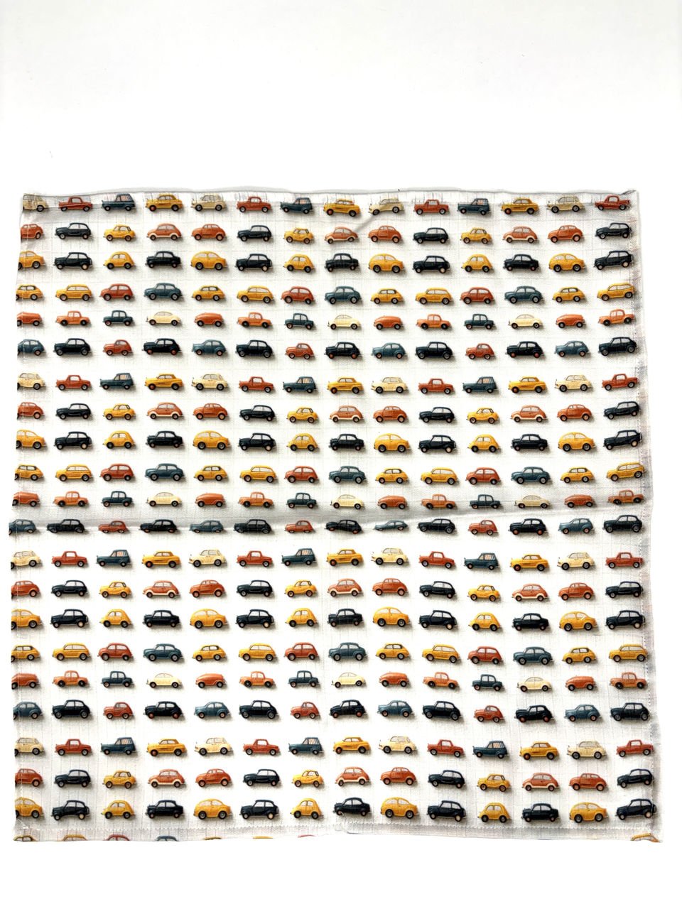 Vzorek látky s motivem aut v různých barvách.