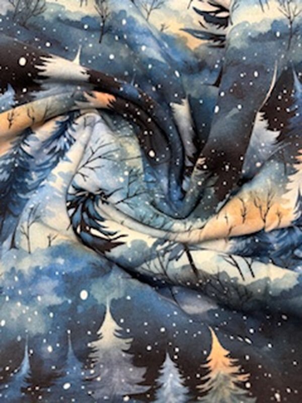 Zimní motivy lesa na látce v modrých odstínech.