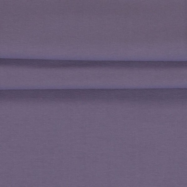 Detail fialové látky na oblečení.