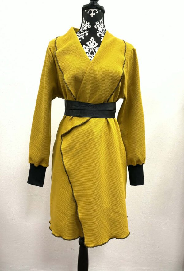 Žluté šaty na figuríně s černými detaily.