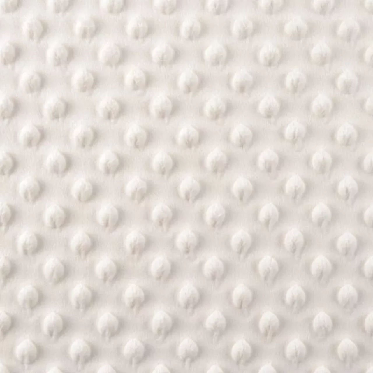 Bílá textilie s 3D puntíkovým vzorem.