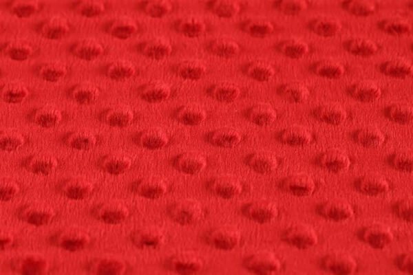 Detail červené textilie s texturou.