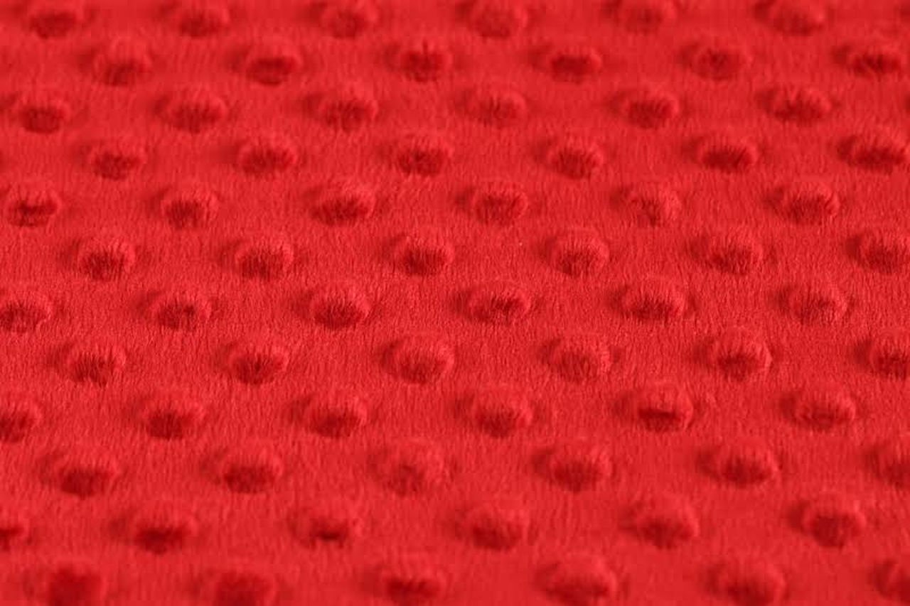 Detail červené textilie s texturou.