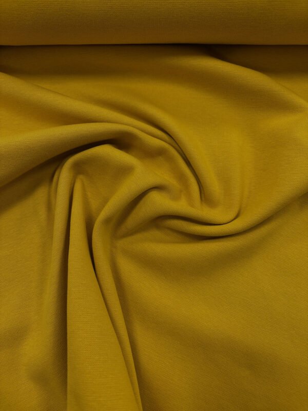 Žloutkově žlutá látka, složená a zvlněná