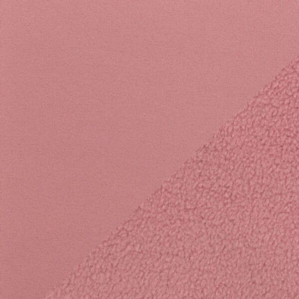Detail růžové látky a textury flísu.